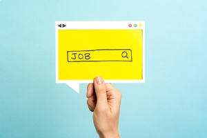 A hand holding Job search cut-out on blue background.Retirement plan consulting helps drawing in job candidates