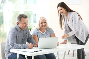 Female insurance agent consulting senior couple in office