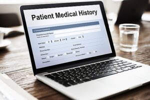 Laptop on desk with Patient Medical History on screen