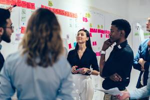 coworkers discussing and setting goals in office. Retirement Plan Consulting help remain productive and engaged